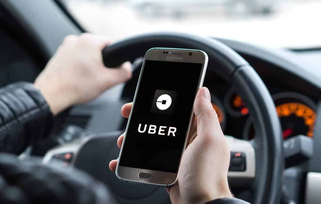 Aluguel de carro para Uber: #PraCegoVer a foto mostra as mãos de um homem segurando um celular e na tela o aplicativo Uber de transporte, dando a entender que é um motorista por aplicativo